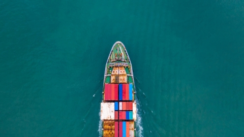 Frachtschiff bewegt sich durch ein großes Gewässer