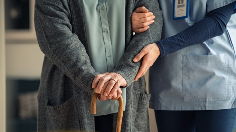 Pflegekraft hilft älterem Patienten