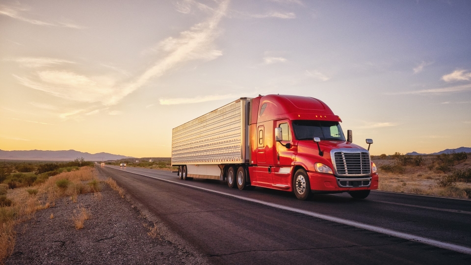 Roter LKW fährt auf der Autobahn
