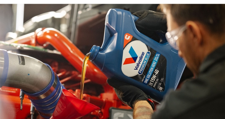 Ein Mitarbeiter gießt Valvoline-Öl in die Anwendung