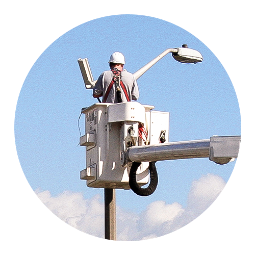 una grúa con plataforma movible junto a un poste de luz
