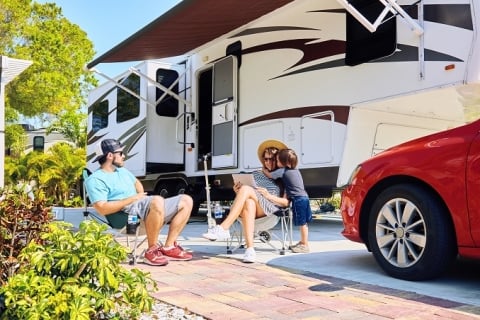 Familia sentada afuera de un RV con montaje