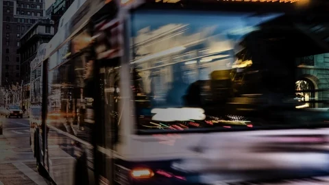 Toma borrosa de un autobús en acción conduciendo por una concurrida calle de la ciudad