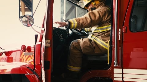 Bombero cerrando la puerta del camión de bomberos.