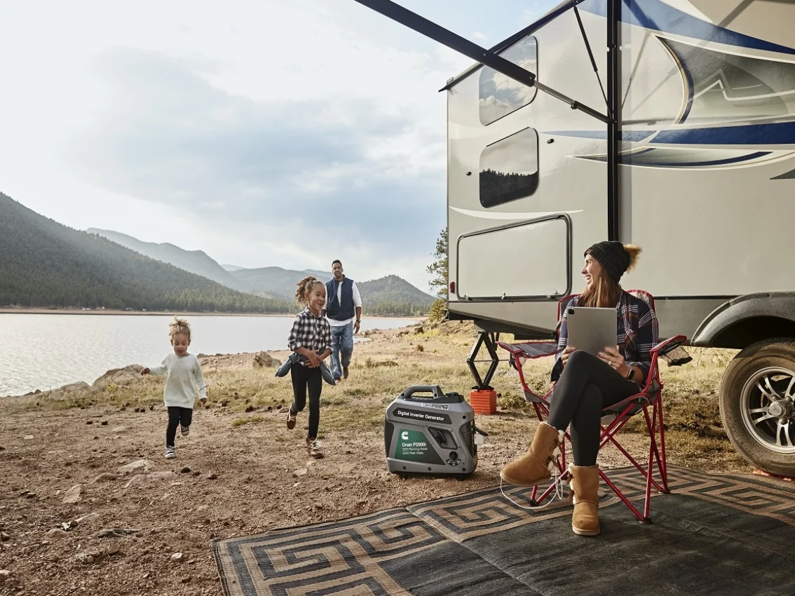 Familia fuera de su RV, cerca de un cuerpo de agua