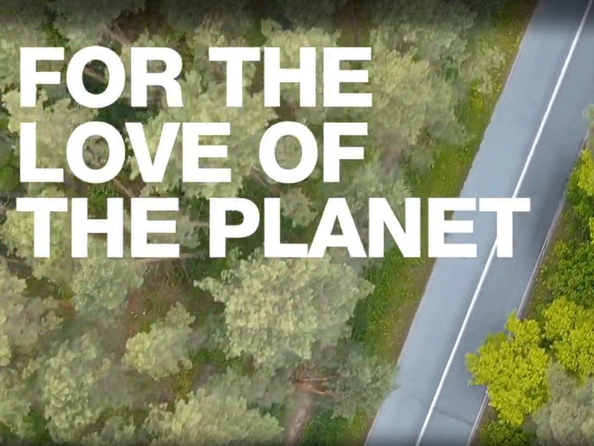 Por el amor al planeta [texto superpuesto sobre un camino en el bosque]