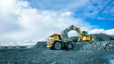 Camión excavador y volquete en sitio minero