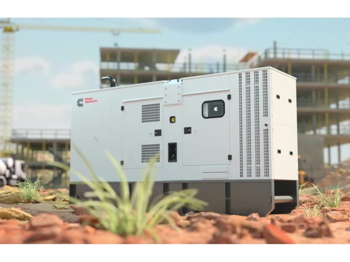 Generador de energía de alquiler de Cummins junto a una obra en construcción