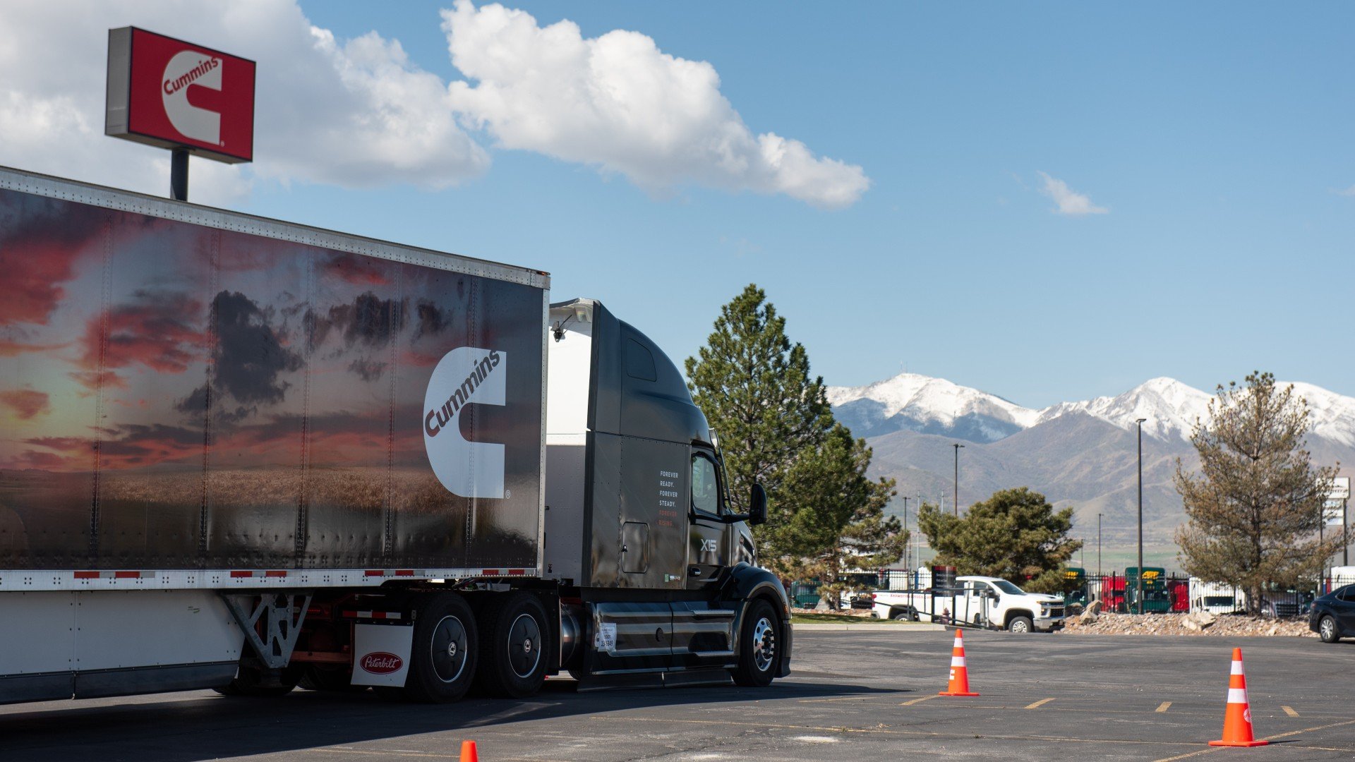 Camion de marque Cummins Forever Rising Tour garé avec un panneau Cummins derrière