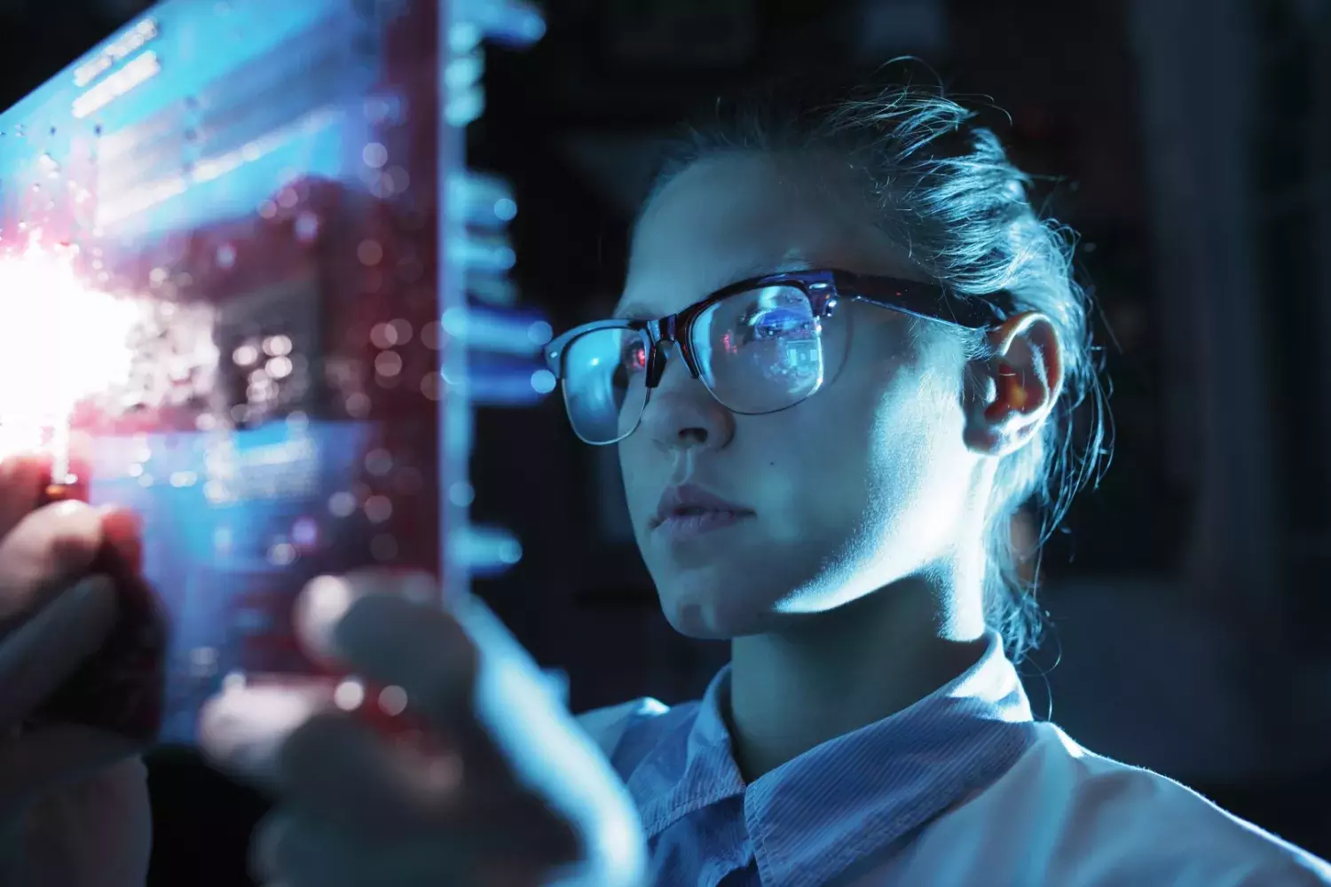 Une femme portant des lunettes de sécurité regarde une tablette avec des données