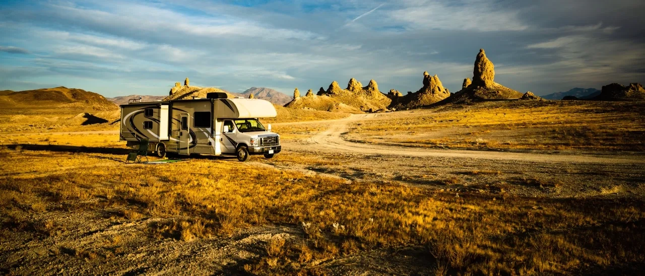 camping-car garé sur une route de terre dans le désert