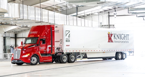 Semi Knight Transportation rouge et blanc garé dans un garage industriel