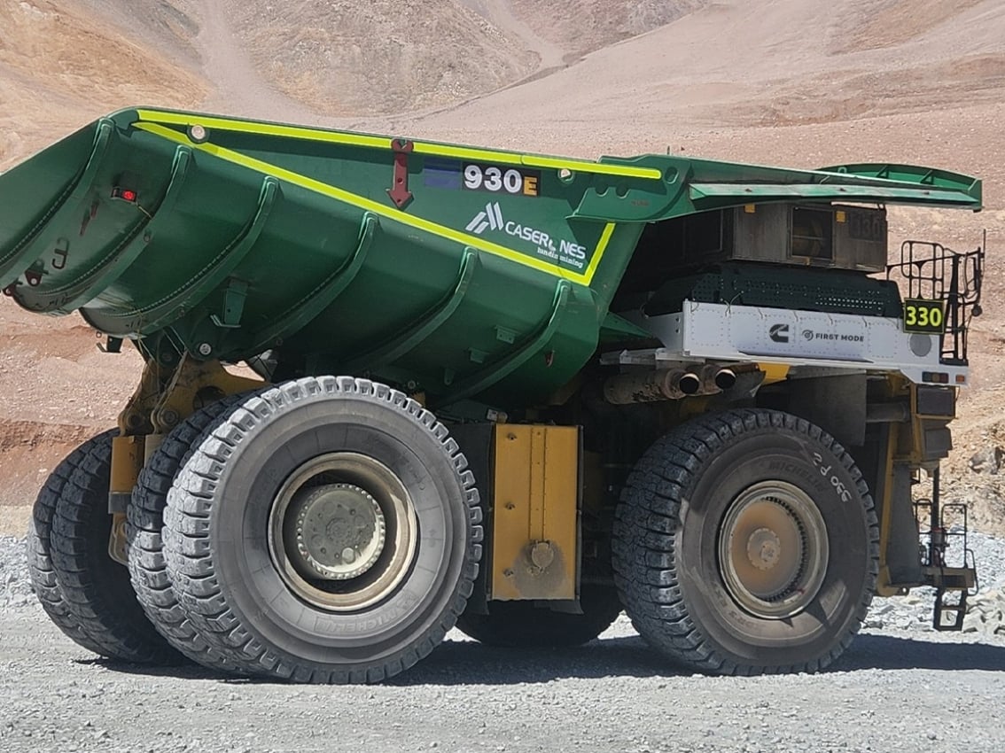 Vue latérale d’un grand camion de transport minier avec une carrosserie verte
