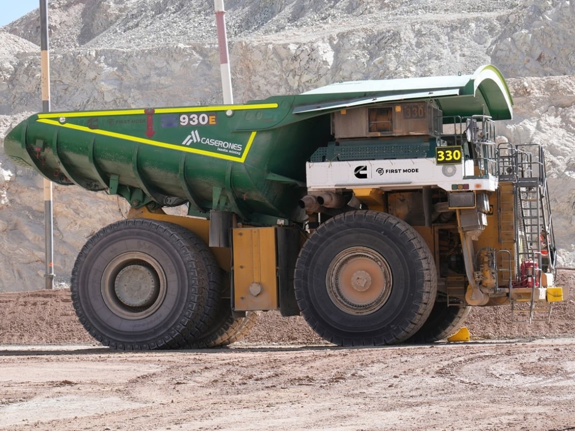 Grand camion de transport minier avec une carrosserie verte garé sur une exploitation minière