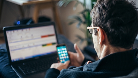 Personne au téléphone et sur ordinateur portable