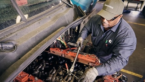 Mécanicien changeant l’huile dans un moteur