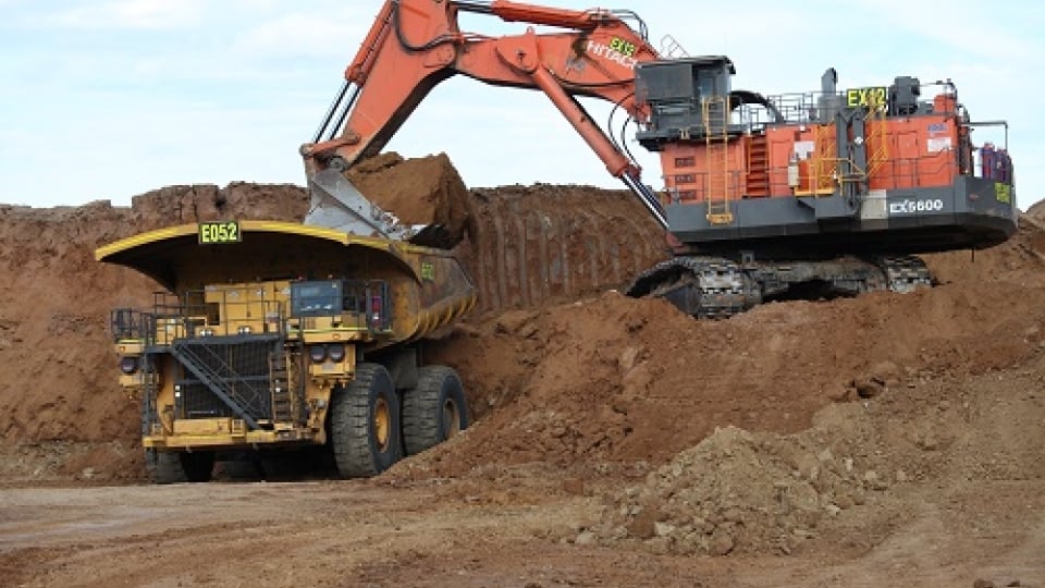 Excavatrice chargeant un camion à benne basculante