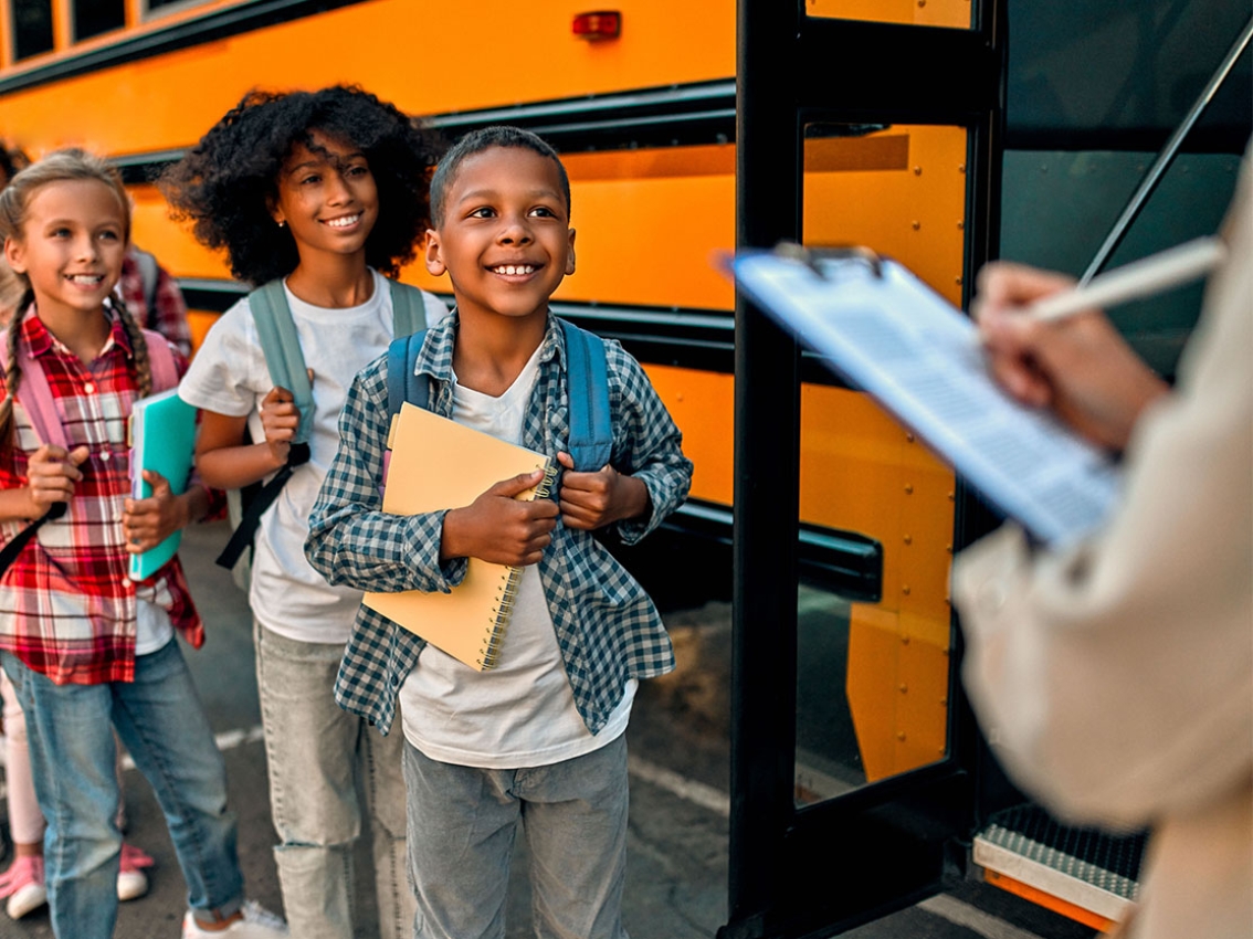 Des enfants sont accueillis à un bus scolaire