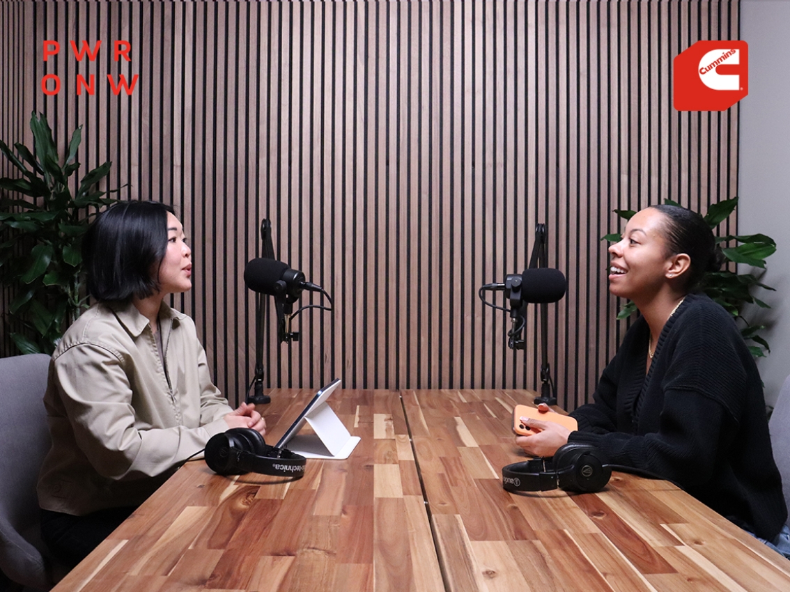 Deux personnes assises à une table pour un entretien de podcast.