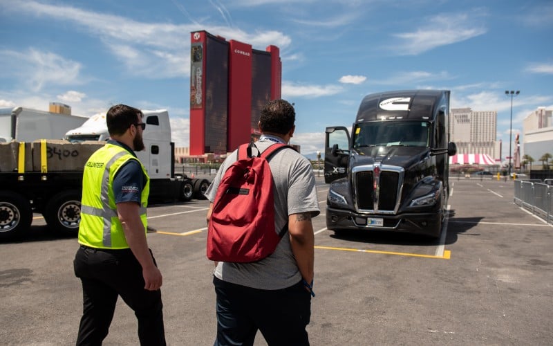 Muškarci posmatraju brendirani kamion "Forever Rising Tour" u blizini kongresnog centra u Las Vegasu