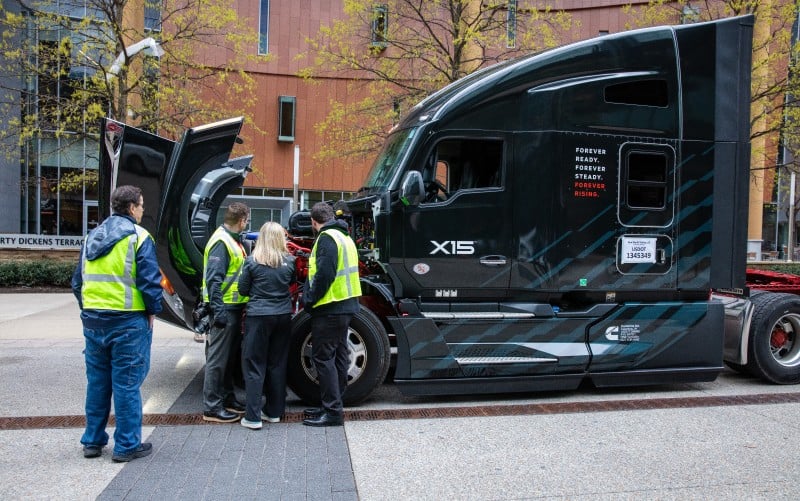 Nekoliko ljudi pregleda motor X15 unutar kamiona marke Cummins