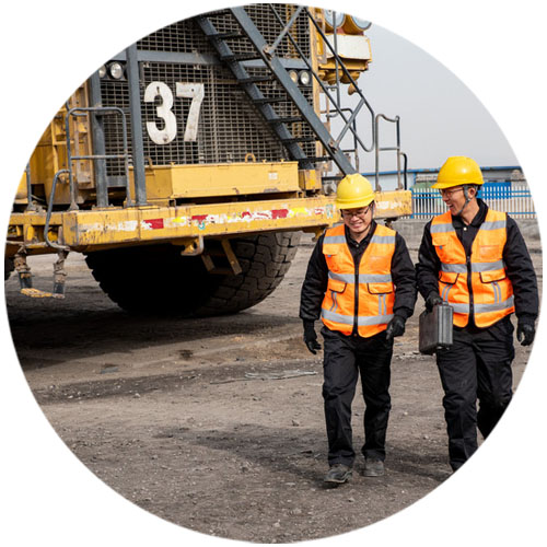 miners in front of mining vehicle