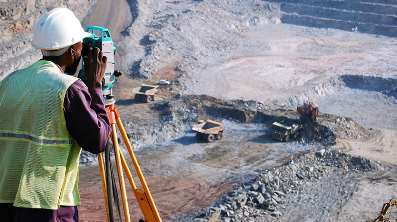 Bergbauexperte bei der markscheiderischen Vermessung einer Mine von oben