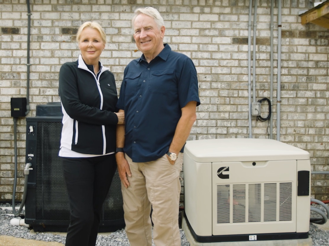 Partners standing beside their home generator