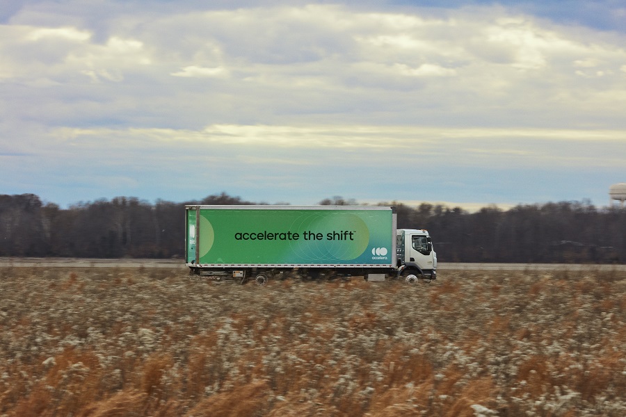 truck driving down the road by fields
