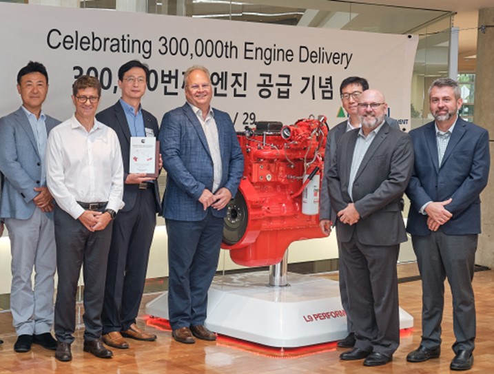 stakeholders standing next to engine prototype
