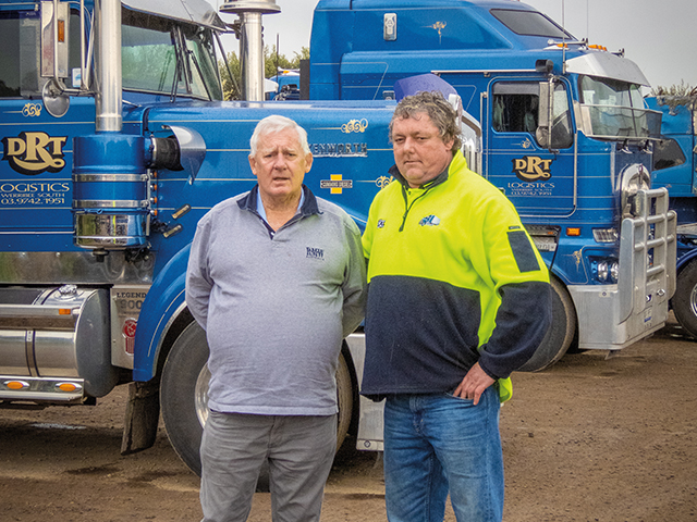 Shane with son in front of semis