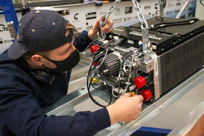 A TU Delft Solar Team member working to install the Cummins HyPM-HD30 fuel cell