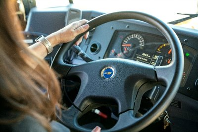 A bus driver operating a Blue Bird electric school bus