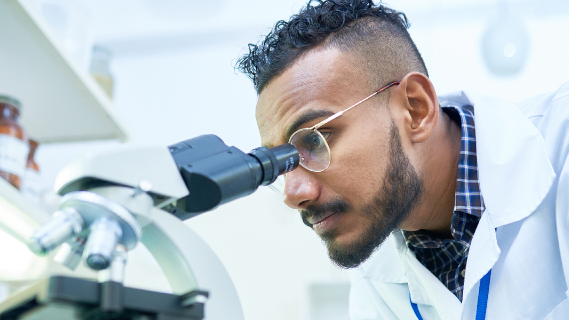 scientist looking at samples through a microscope
