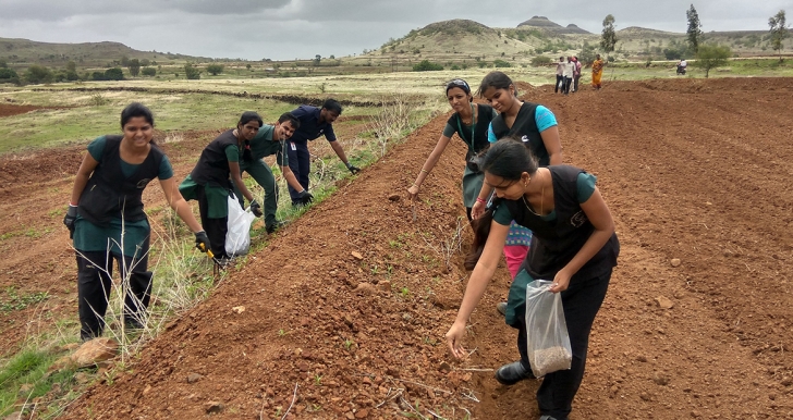 Cummins employees work on a grass-seeding project to help a community conserve water in India. This photo was taken prior to the COVID-19 pandemic.