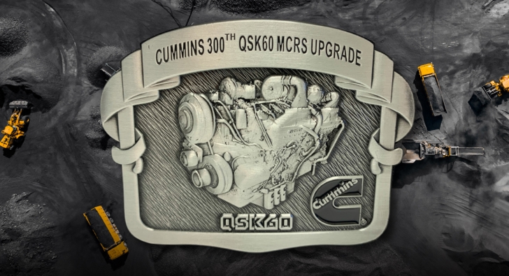 「Cummins 300th QSK60 MCRS Upgrade」という文字の入ったベルトのバックル