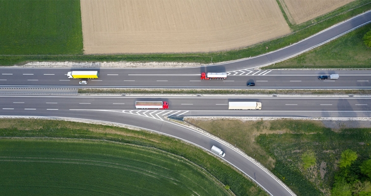Red, yellow and white buses driving down a highway