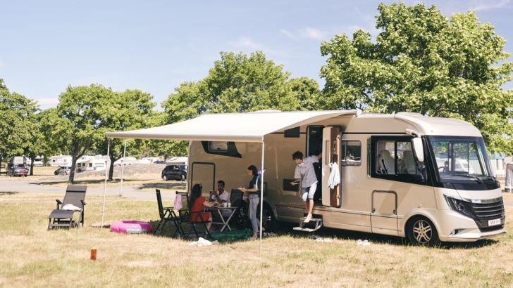 a family gathers for a meal under their rv canopy