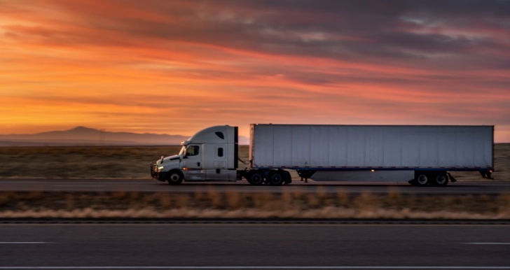 Semi truck on road with sunset