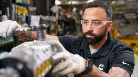 Cummins technician performing hands‑on work on engine