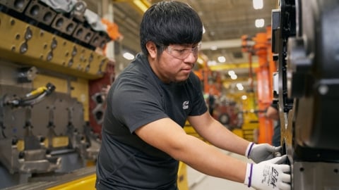 Cummins team member handling engine equipment