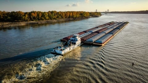 tug boat pushing barge in large river