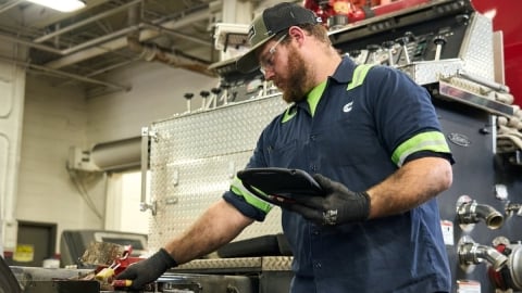 shop technicians with safety glasses and gloves on inspecting parts