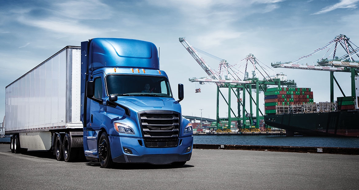 Blue and white Freightliner next to construction equipment