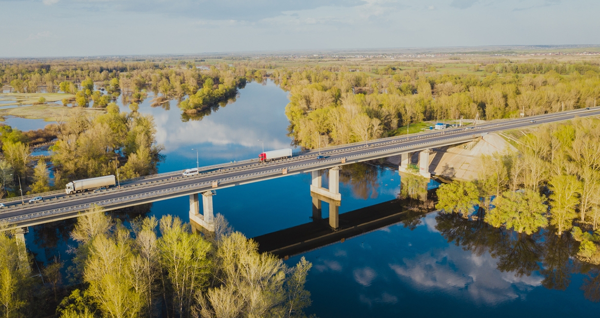 semi driving over a bridge over a river