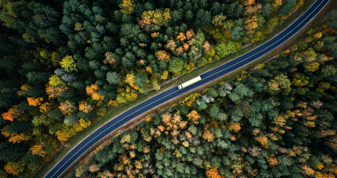 semi on highway through the forest