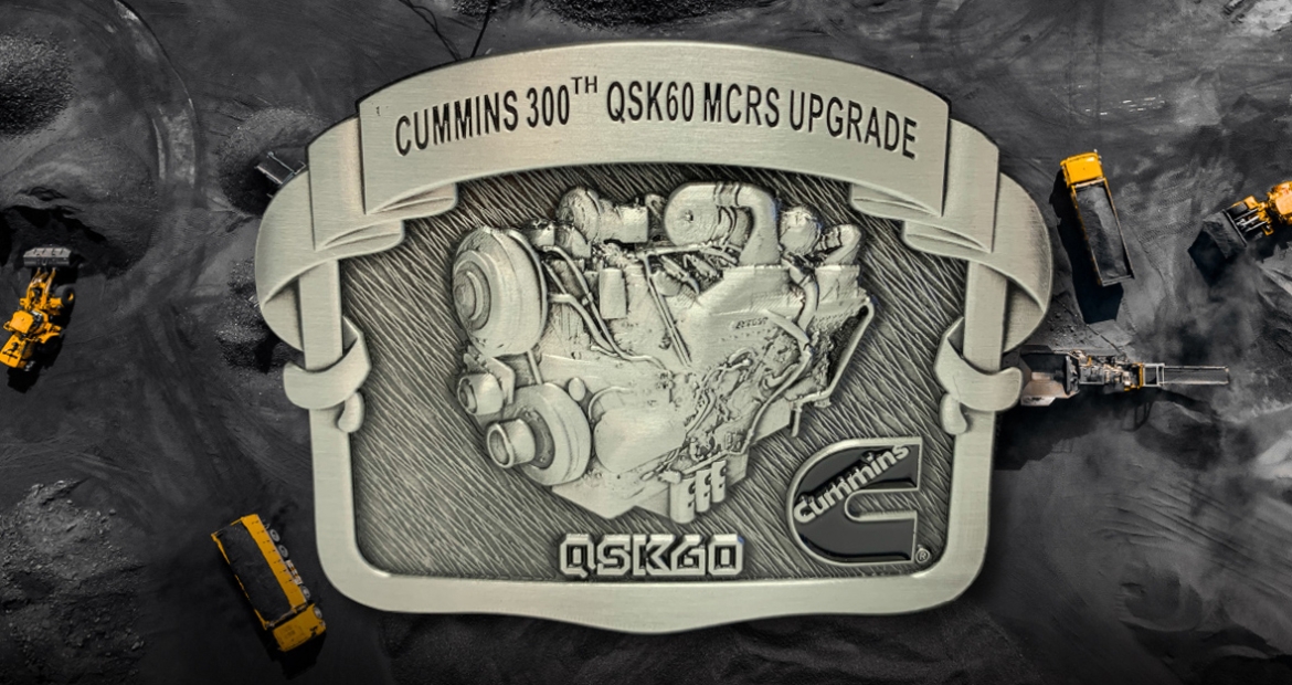 belt buckle with text reading "Cummins 300th QSK60 MCRS Upgrade"