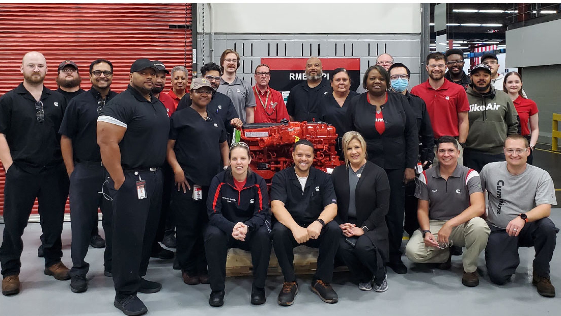 RMEP employees standing next to Cummins engine