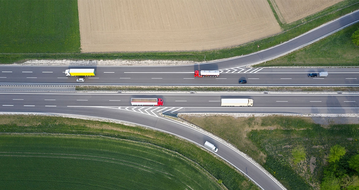Red, yellow and white buses driving down a highway