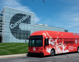 Autobus Cummins zaparkovaný u závodu